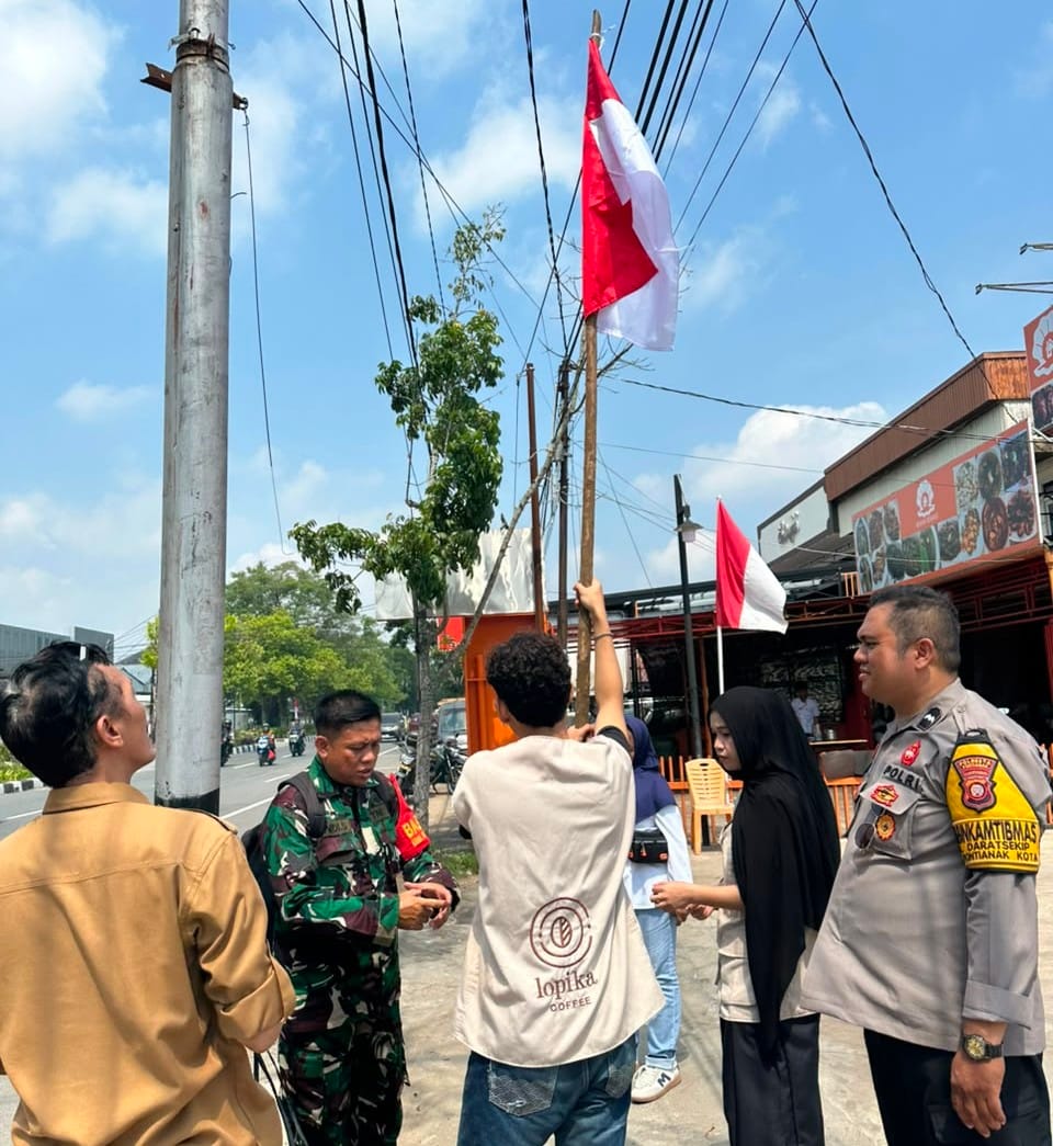 Semarak HUT RI ke-81, Bhabinkamtibmas dan Babinsa Edukasi Pelaku Usaha Kibarkan Sang Merah Putih