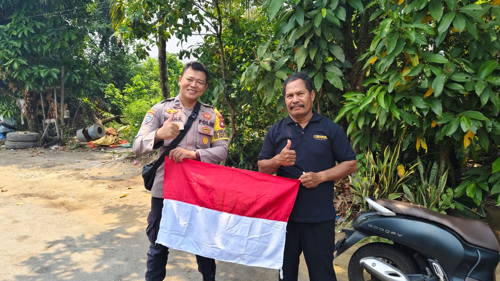 Semarak HUT RI ke-81, Bhabinkamtibmas Siantan Hulu Bagikan Bendera Merah Putih kepada Warga