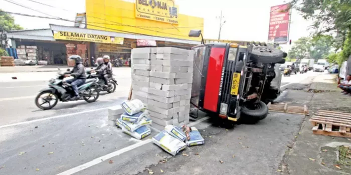 Kelebihan Muatan, Truk Bata Ringan Terbalik di Jalan Raya Blimbing​