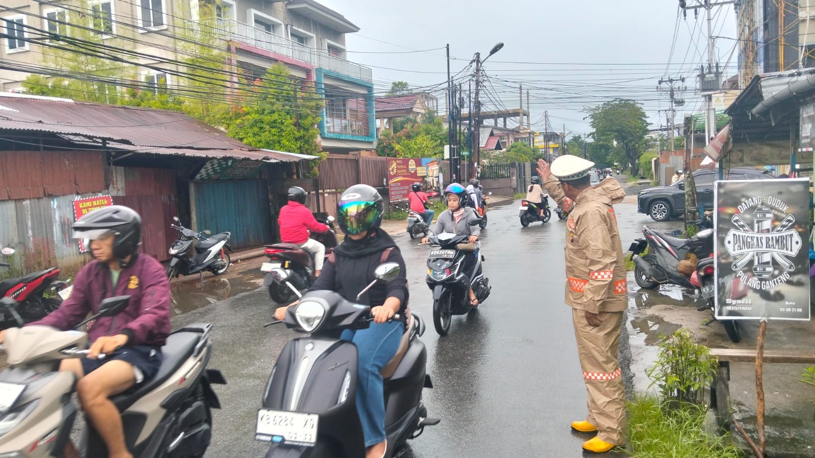 Personel Polsek Pontianak Selatan Berbekal Mantel Tetap Lakukan Pengaturan Lalu Lintas di Tengah Hujan, Cegah Kemacetan