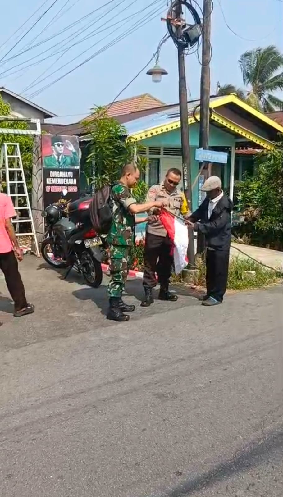 Jelang HUT Kemerdekaan RI, Bhabinkamtibmas Banjar Serasan dan Babinsa Ajak Warga Kibarkan Merah Putih