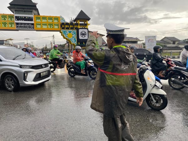 Meski Hujan, Unit Lantas Polsek Pontianak Timur Tetap Laksanakan Pengaturan Pagi di Simpang Tanjung Raya