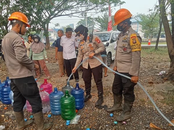 Kapolsek Pontianak Selatan Bersama Sat Brimob Polda Kalbar dan Camat Pontianak Tenggara Salurkan Air Bersih Siap Konsumsi untuk Warga.